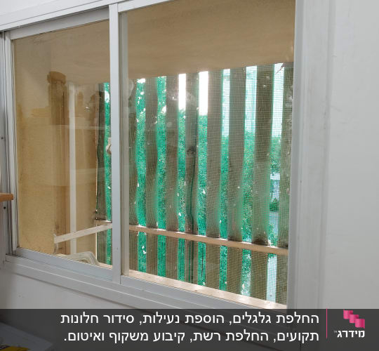 תריסים ירוקים עם רשת על חלון זכוכית